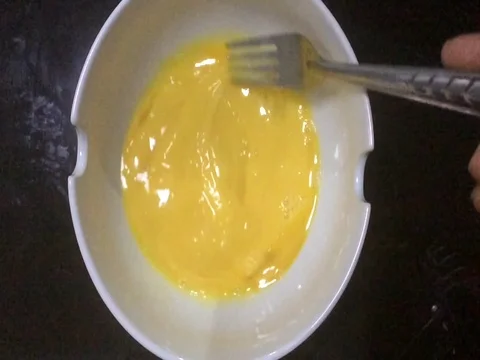 Beat the egg in a white bowl. 스톡 동영상 76859309
