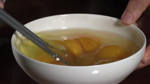Beat the eggs with a chopsticks. Stock Footage 296933085