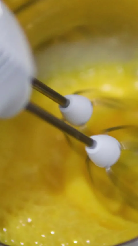 Beat eggs with a hand mixer Dipping a switched on mixer into a metal bowl, for Stock Footage 279917063