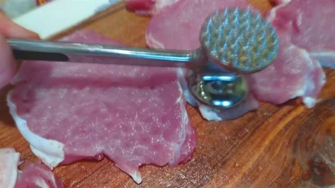 Beat off pieces of meat with a hammer Stock Footage 300021539