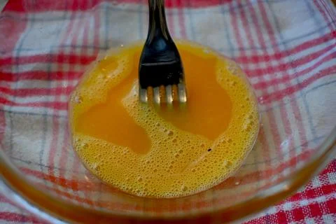 Beaten egg with fork for cooking 库存照片