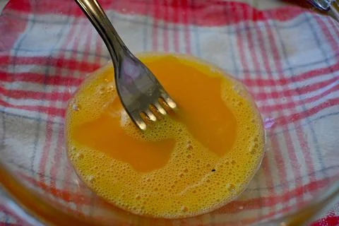 Beaten egg with fork for cooking Fotos Stock