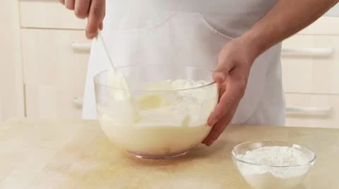 Beaten egg white being mixed with egg yolk cream and flour being added Stock Footage 24638901
