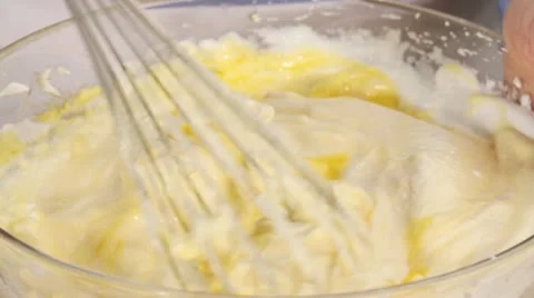 Beaten egg whites being mixed with egg yolk Stock Footage 24671012