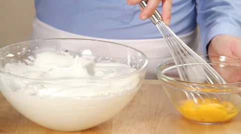 Beaten egg yolk being folded into beaten egg white Stock Footage 24671001