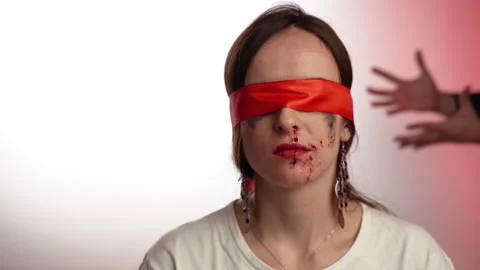 Beaten female with closed eyes and bleeding nose sitting on background of Stock Footage 130407553