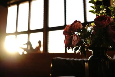 Beatiful artificial flowers with blurred posing girl model Stock Photos