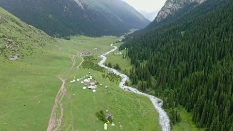Beatiful Drone Flight Over Riverbed and Traditional Yurt Camp in Altyn Arashan Stock Footage 346904785