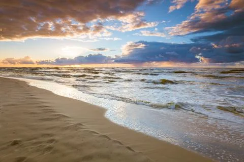 Beatiful sunset with clouds over sea and beach Stock Photos