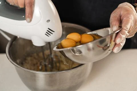 Beating cake mix to whip with the egg yolks about to be added Stock Photos