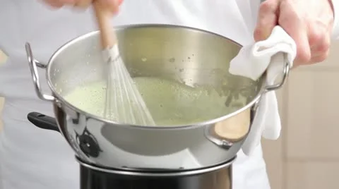 Beating creme in bowl over pan of simmering water Stock Footage 24665739