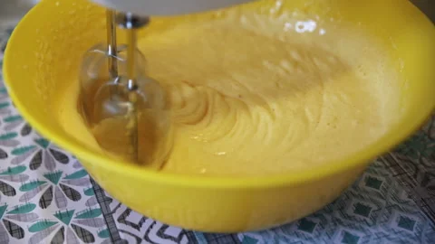 Beating Egg and Sugar Batter with Electric Mixer in a Yellow Bowl Stock-Footage 332730764