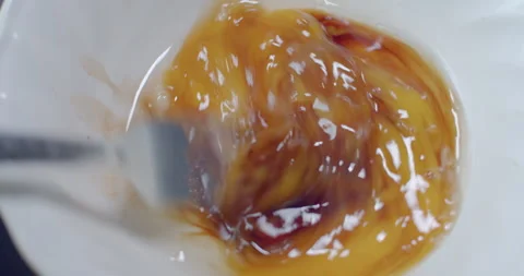 Beating an egg with a fork to mix yolk and white evenly. Stock Footage 312284301