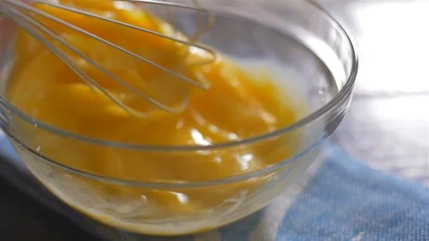 Beating of eggs in a bowl. Slow motion. Vídeo Stock 106472385