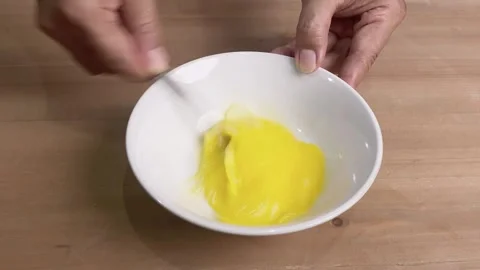 Beating eggs in a bowl with spoon Video stock 345587484