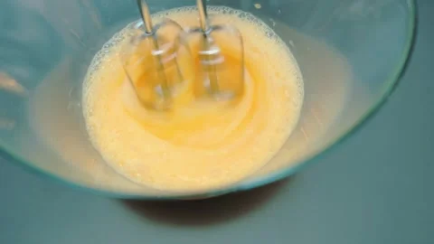 Beating eggs with a mixer in a deep bowl Stock-Footage 252484841