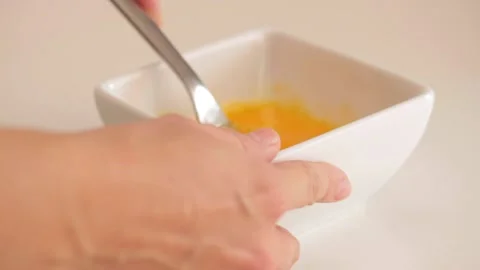 Beating eggs in a small bowl Stock Footage 133813910