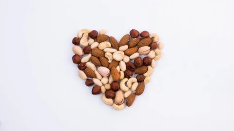 The beating of the heart made of nuts. Assorted nuts forming heart. Stop motion Stock Footage 72717099