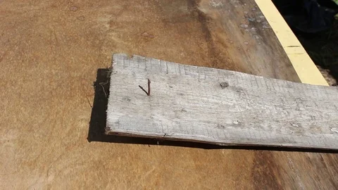 Beats out the old nails from the boards and pulls them with a hammer Stock Footage