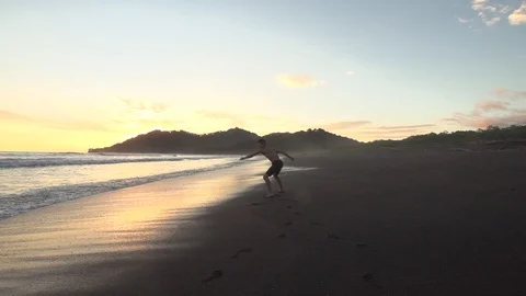Beatuiful Black Sand Beach Sunset Flipping Tricks in Slow Motion Stock Footage 87723524