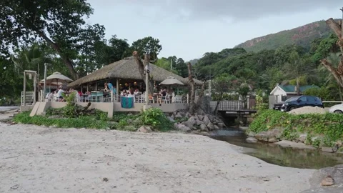 Beau Vallon evening beach on Mahe Island with a cozy cafe on banks of a river Vidéo 331506589