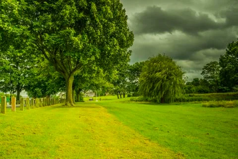 Beauiful park landscape with cloudy sky Stock Photos