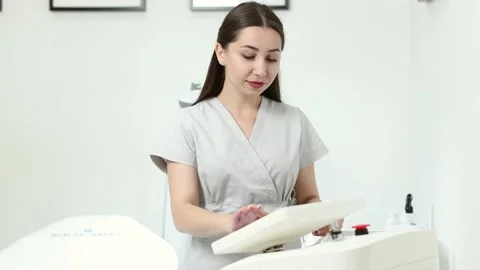 Beautician adjusts the parameters on the display before laser hair removal Stock Footage 229333872