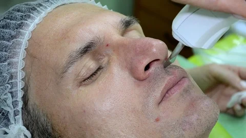 Beautician does procedure on the face of man with ultrasound device closeup Stock Footage 112301955