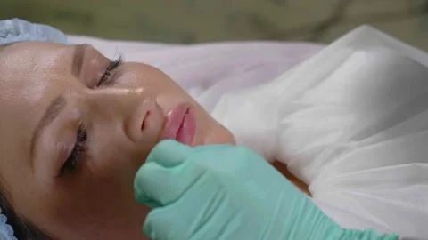 Beautician does the procedure of lip augmentation with a hyaluron injection Stock Footage 135633798