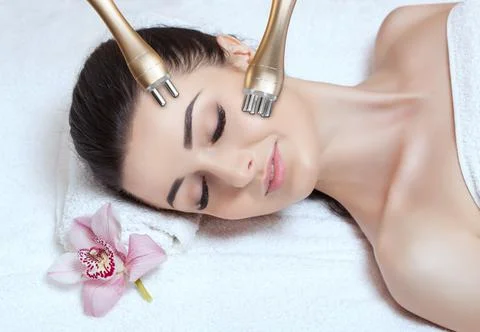 Beautician does the procedure rf-lifting on face and neck. Rf lifting procedu Stock Photos