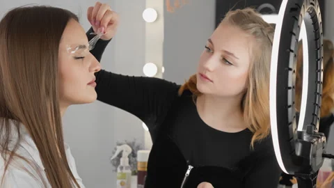 Beautician, eyebrow master demonstrates the process of creating expressive Stock Footage 240129084