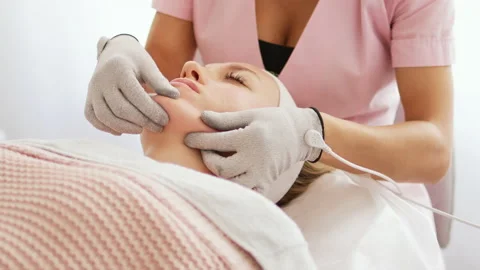 Beautician makes microcurrent procedure on face Stock Footage 214041111
