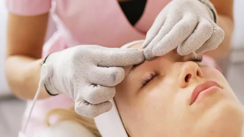 Beautician makes microcurrent procedure on face Stock Footage 214041445