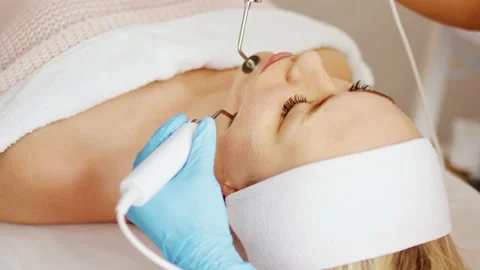 Beautician makes procedure on the face microcurrent device Stock Footage 219320158