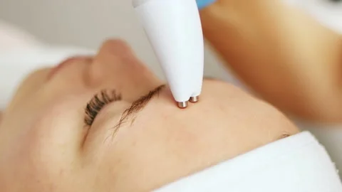 Beautician makes a procedure on the face with microcurrent therapy Stock Footage 236025699