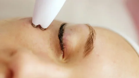 Beautician makes a procedure on the face with microcurrent therapy Stock Footage 238753271