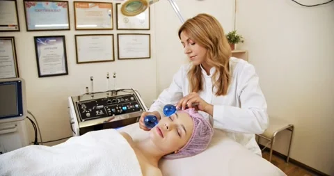 Beautician making a massage of the  face using the blue balls. Woman in a spa Stock Footage 151672880