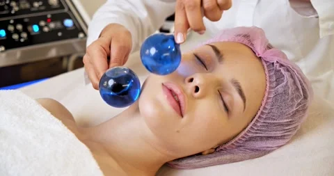 Beautician making a massage of the  face using the blue balls. Woman in a spa Stock Footage 151672932