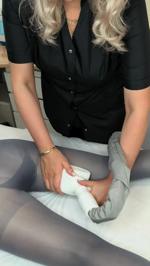 Beautician performs LPG vacuum roller massage on a woman's thigh in a beauty Stockbeeldmateriaal 341767541