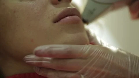 Beautician performs a procedure on the face of the young beautiful girl Stock Footage 73769009