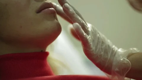 Beautician performs a procedure on the face of the young beautiful girl Stock Footage 73769077