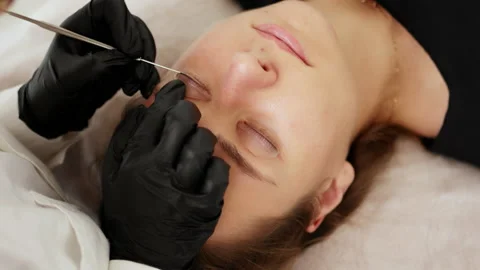Beautician separates eyelashes with using a special tool Stock Footage 232412869