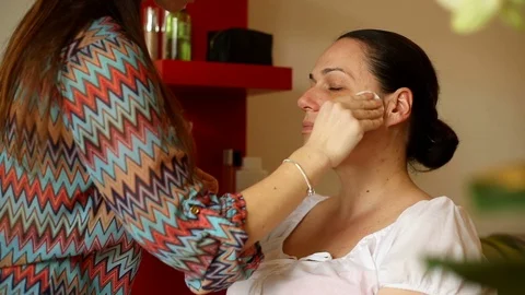 Beautician using cotton pad while cleaning face of her client Video stock 73684464