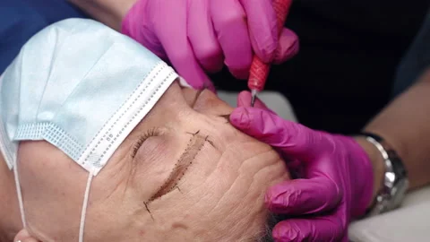 Beautician using tattoo machine for permanent eyebrows correction procedure Stock Footage 199992840