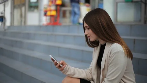 A beautiful 15 year old is talking on the phone and waving to someone Vidéo 114528952