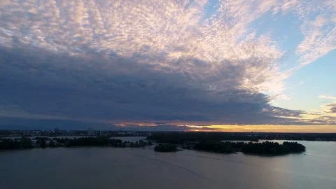 Beautiful 4K sunset. Sun shining behind clouds low from horizon. Drone rising Stock Footage 78758432
