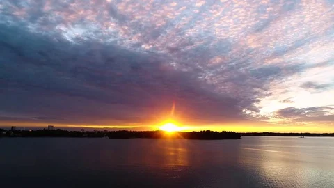 Beautiful 4K sunset. Sun shining behind and bellow clouds low from horizon Stock Footage 78780686