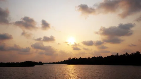 A beautiful 4K time-lapse of the sun setting over a calm tropical river. Stock Footage 341654540