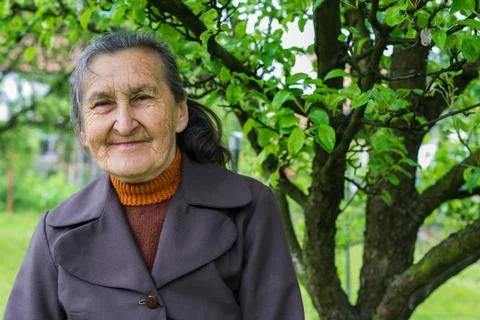 Beautiful 80 plus year old senior woman posing for a portrait in her garden. Foto stock