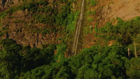 Beautiful aerial drone medium close-up of a slender waterfall stream flowing Stockbeeldmateriaal 335710470